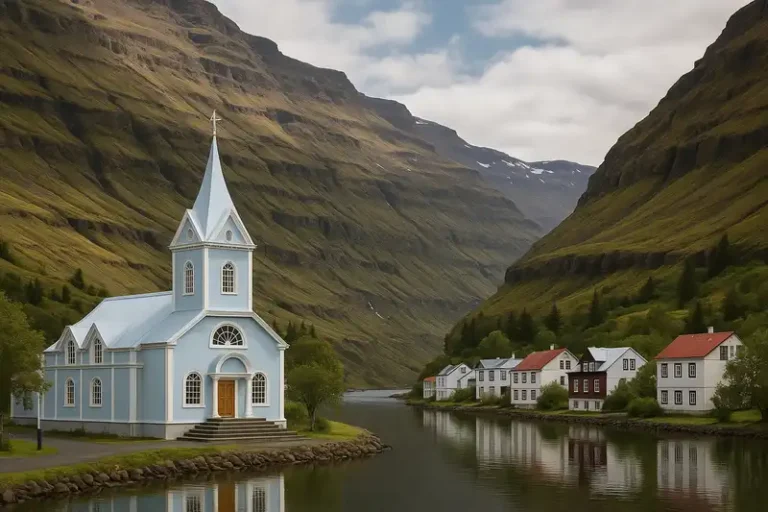 Eastfjords 5 The quaint town of Seyðisfjörður, with its iconic light blue church, is nestled at the base of steep, towering mountains at the very end of a deep fjord in Iceland, Eastfjords, Iceland.