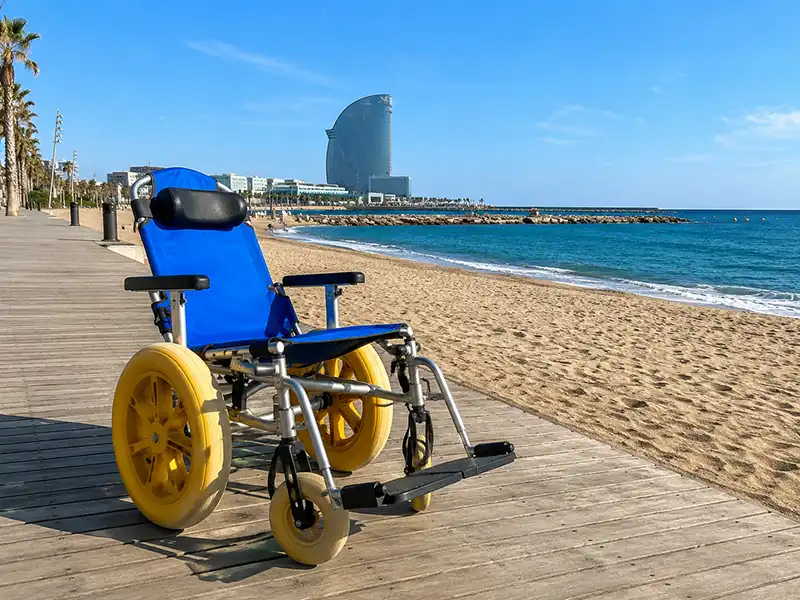 Accessible Travel Destinations in Europe: Best Cities for 2026 3 Accessible travel destinations Europe - Beach wheelchair on the accessible wooden boardwalk at Barceloneta Beach, Barcelona