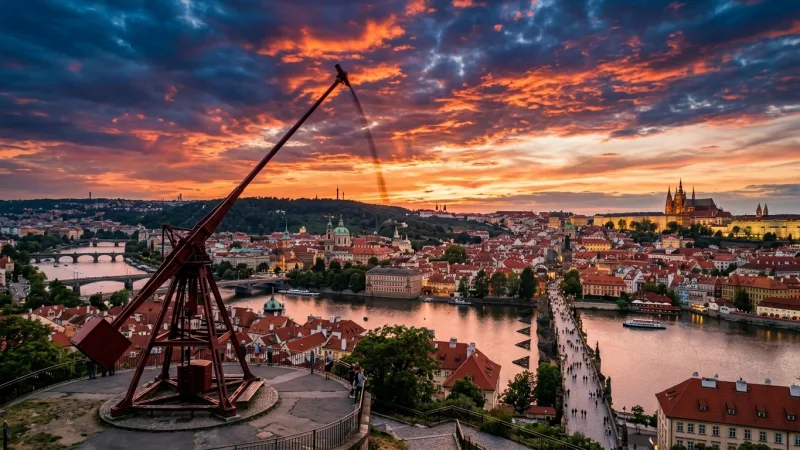 Visit the Prague Metronome 3 The large red Prague Metronome statue overlooking the city of Prague and the Vltava River.