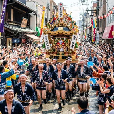 Crowds cheering as men in traditional attire carry an ornate festival float through the streets of Fukuoka.