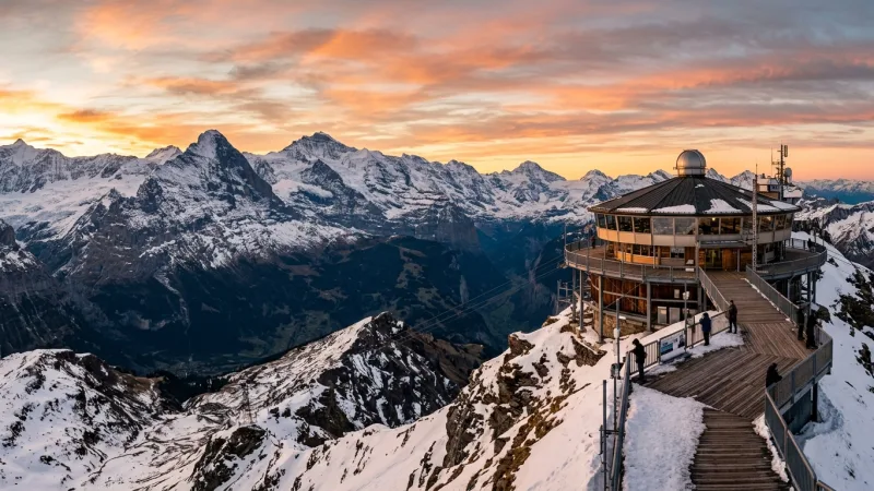 The iconic Piz Gloria revolving restaurant structure atop the sharp snowy Schilthorn mountain peak.