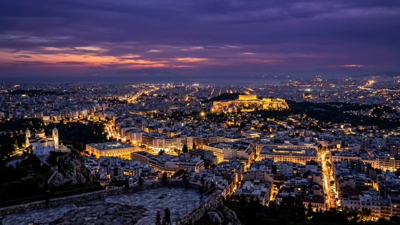 Timing Your Visit for Dual-Light Views 1 Athens city landscape at twilight from Mount Lycabettus showing city grid lights and the illuminated Acropolis.
