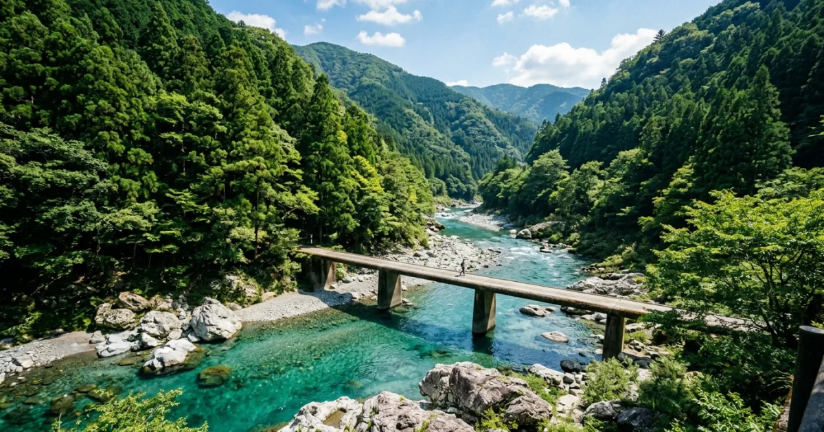 Turquoise waters of the Niyodo River surrounded by green mountain forests in Kochi Prefecture, Japan.