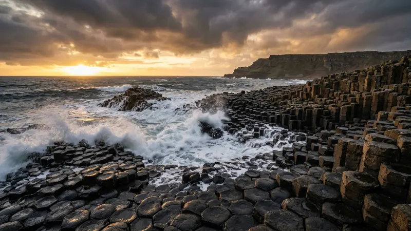 Walk the Causeway Coastline for Free 6 Geometric basalt rock formations meeting the ocean under a dramatic cloudy sky.